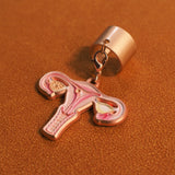 Detailed view of a pink and gold uterus anatomy stethoscope charm